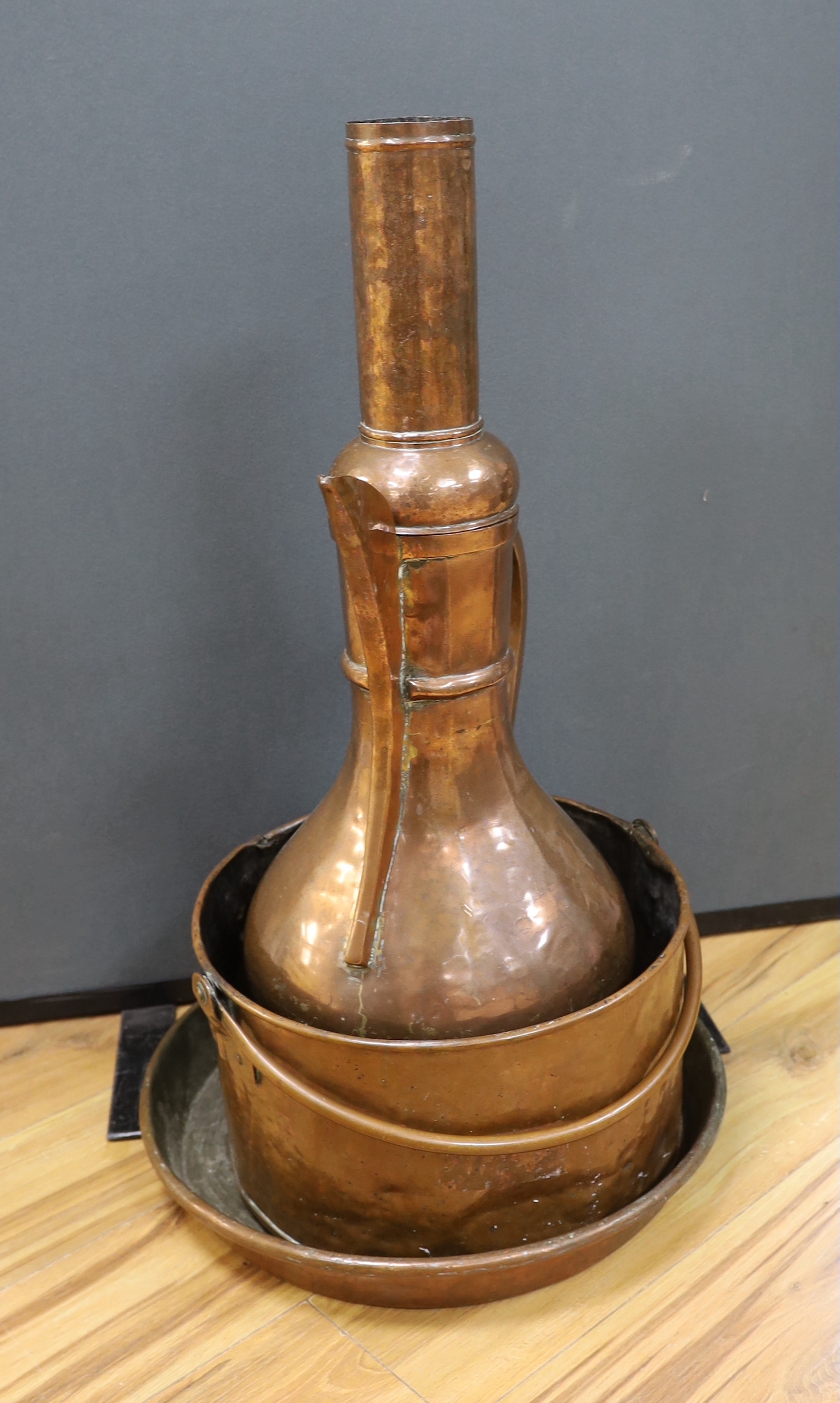 A shallow copper dish a copper cooking pot and a large, Middle Eastern coffee pot,-77cm high